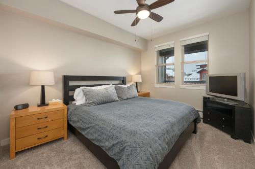 a bedroom with a bed and a flat screen tv at Ski-In / Ski-Out 1 Bedroom Condo base of WP Resort in Winter Park
