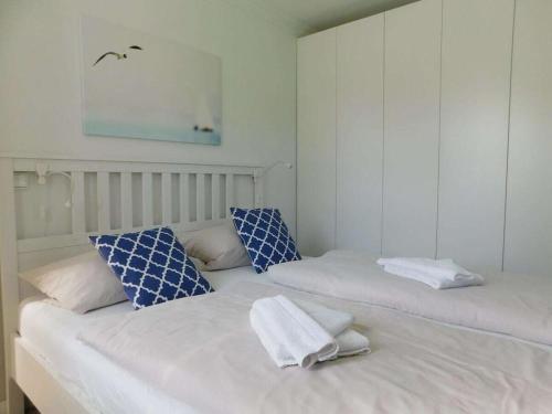 two beds with towels on top of them in a room at Refugium 54° Timmendorfer Strand in Timmendorfer Strand