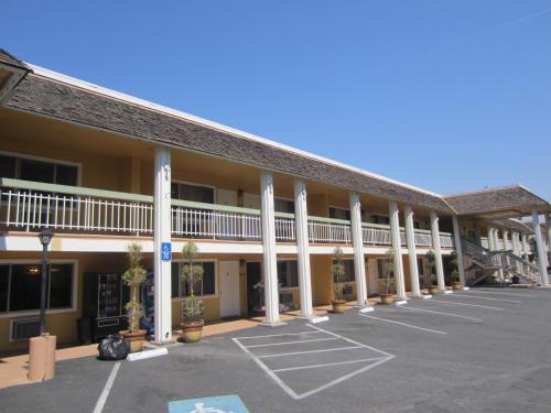 um parque de estacionamento vazio em frente a um hotel em Caravelle Inn Extended Stay em San José