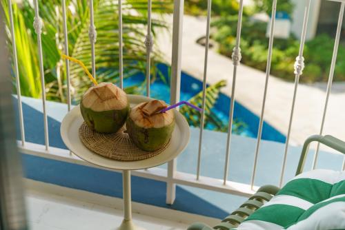 two coconuts on a plate next to a window at Title Halo Nature Touch 40m2 King Bed Naiyang in Nai Yang Beach