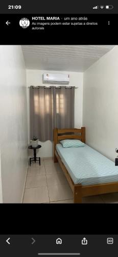 a picture of a bedroom with a bed and a table at Hotel Maria in Marabá