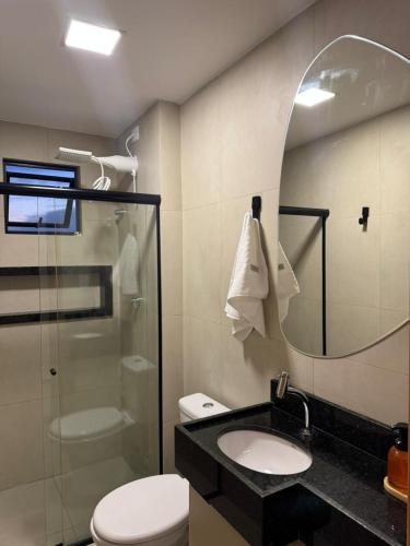 a bathroom with a toilet and a sink and a mirror at Apto 2 Quartos Novo e Super Confortável in Arapiraca