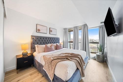 a bedroom with a large bed and a television at Spacious Downtown Condo - Walk to CN Tower & More in Toronto