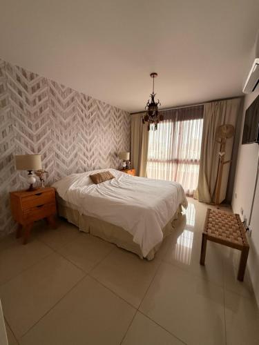 a bedroom with a bed and a table and a window at City Paz in Villa Carlos Paz