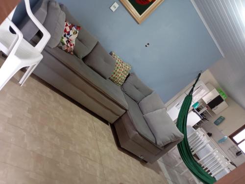 a living room with a couch and a white chair at Casa Amarela in São Francisco do Sul