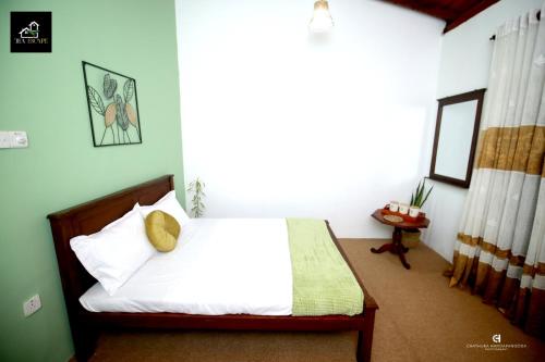 a bedroom with a bed with white sheets and pillows at Tea Escape Holiday Villa and Cabanas in Gampola