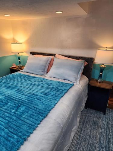 a bedroom with a large bed with a blue blanket at Old Salem House 15 mins from downtown Salem in Peabody