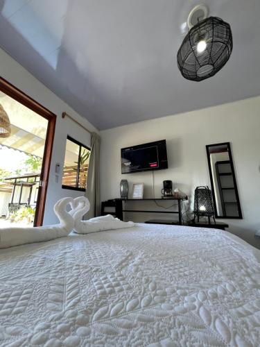 a large white bed in a room with a window at Chinuk Boutique Hotel in Puerto Viejo