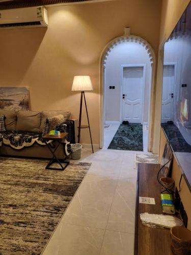 a hallway with a living room with a couch and a table at المسكن الزاهي الامير فواز in Jeddah