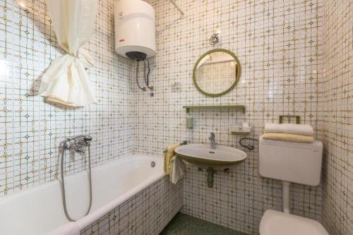 a bathroom with a sink and a tub and a toilet at Apartments and rooms by the sea Tucepi, Makarska - 24679 in Tučepi