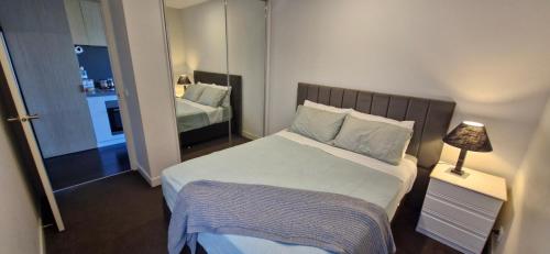 a small bedroom with a bed and a mirror at Ascot Hill in Melbourne