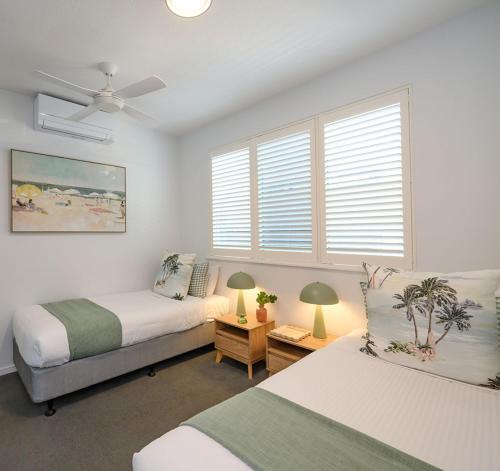 5 "Sempre" 28-34 Duke St Sunshine Beach في صن شاين بيتش: غرفة نوم بها سريرين ونافذة
