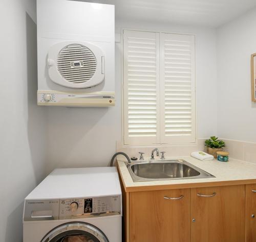 5 "Sempre" 28-34 Duke St Sunshine Beach في صن شاين بيتش: مطبخ مع حوض وغسالة ملابس
