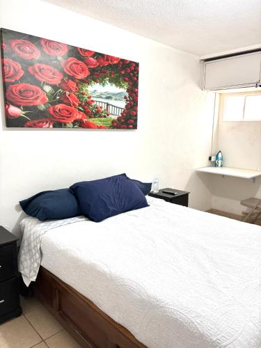 a bedroom with a bed with a painting on the wall at Cómodo departamento 2 cerca del centro de gobierno , CAS, Consulado , CRIT in Hermosillo