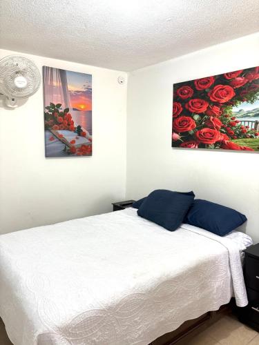 a bedroom with a bed with two paintings on the wall at Cómodo departamento 2 cerca del centro de gobierno , CAS, Consulado , CRIT in Hermosillo
