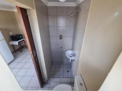 a bathroom with a shower with a toilet and a sink at Bird Retreat in Zeekoevlei
