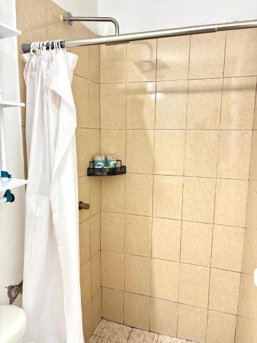a shower with a white shower curtain in a bathroom at Cómodo departamento 2 cerca del centro de gobierno , CAS, Consulado , CRIT in Hermosillo