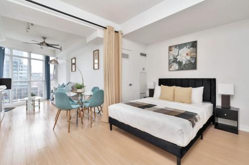 a bedroom with a bed and a table and chairs at Sunny Downtown TO Studio - Sleeps 3 with 55 TV in Toronto
