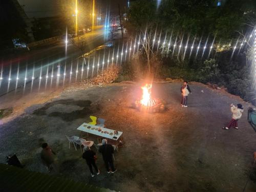 a group of people standing around a fire at night at Như Ý Hotel in Kon Plong