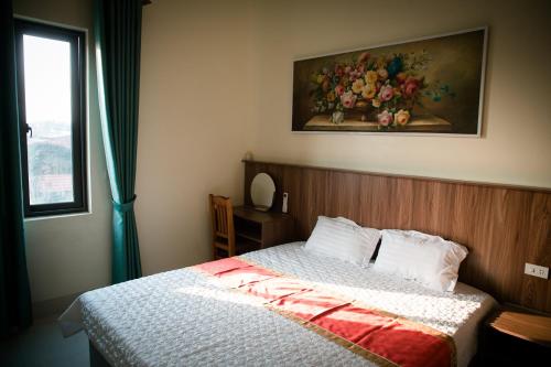 una camera da letto con un letto e un dipinto sul muro di Tam Coc Michoc Homestay a Ninh Binh