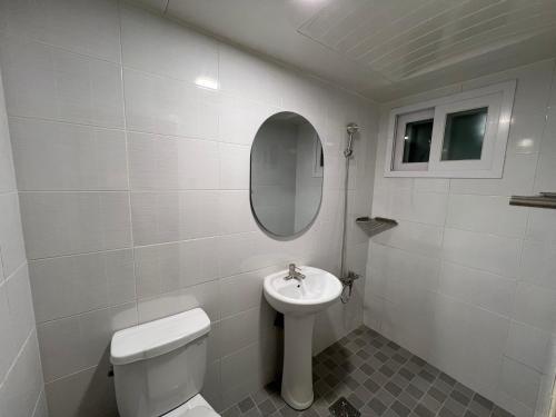a white bathroom with a toilet and a sink at Wayhome Gasan in Seoul