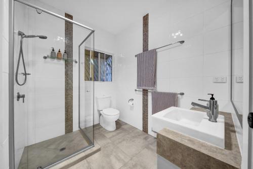 a bathroom with a shower and a sink and a toilet at Cypress Sea Breeze in Woorim