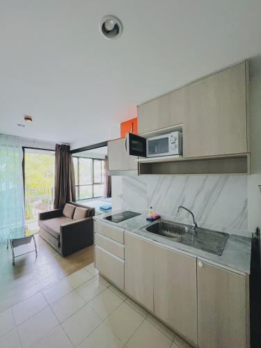 a kitchen with a sink and a living room at 38Nice room phuket town near Shopping Malls and Naka night market in Phuket