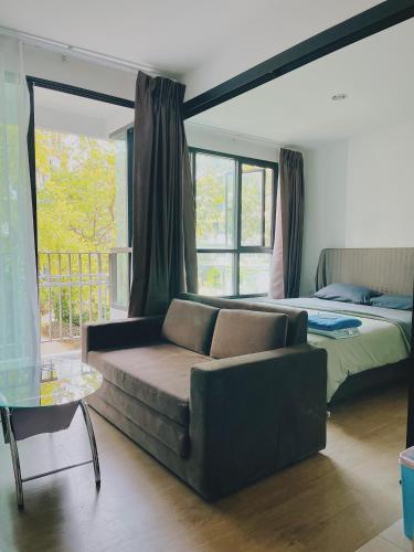 a living room with a couch and a bed at 38Nice room phuket town near Shopping Malls and Naka night market in Phuket