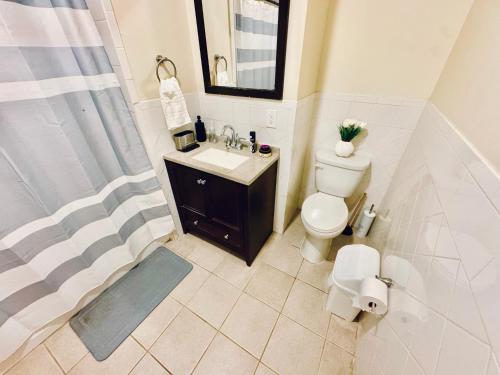 a bathroom with a toilet and a sink and a shower at Modern Luxury Executive Room with NYC Fast Access in Paterson