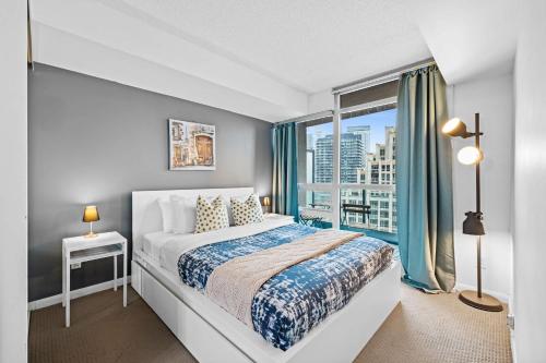 een slaapkamer met een bed en een groot raam bij Spacious 3BR Condo with Patio & Free Parking in Toronto