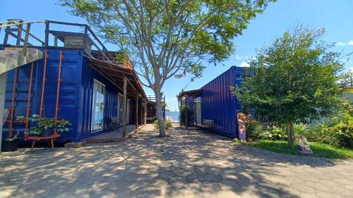a little girl standing next to a blue house at Hospedagem Tribos Livres in Torres