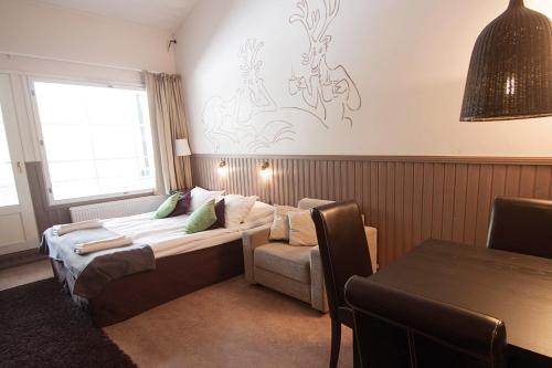 a living room with a couch and a table at Hotel Hullu Poro in Levi