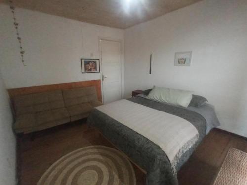 a small bedroom with a bed and a table at Monofacetas Plaza de Armas in La Serena