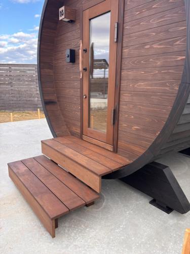 a wooden revolving sauna with a revolving glass door at VILLA Seamu 九十九里 家族と愛犬で楽しむサウナとプール ガラス貼りBBQルーム付き高級ガーデンヴィラ in Kujukuri