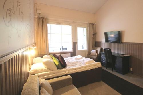 a bedroom with a bed with a window and a couch at Hotel Hullu Poro in Levi