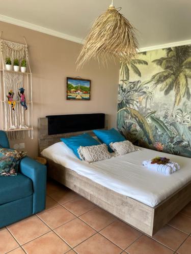 Couleur Caraïbes- 2 Appartements Communicants Vue Mer Pierre&Vacances في سانت لوسي: غرفة نوم بها سرير كبير وأريكة زرقاء