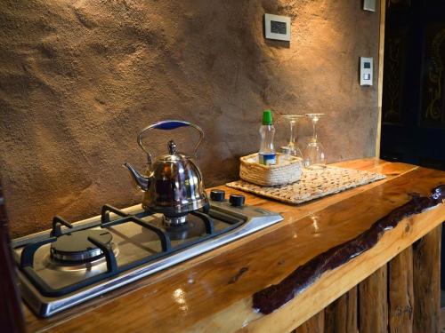 a tea kettle sitting on top of a stove at Refugio de tierra con vistas en Ocoa in Viña Guzmán