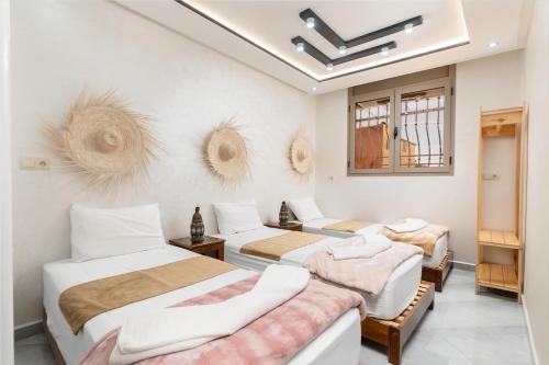 a bedroom with three beds and a wall with three mirrors at jaws wave imsouane in Imsouane