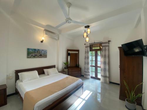 a bedroom with a bed and a flat screen tv at Villa 2A in Matara
