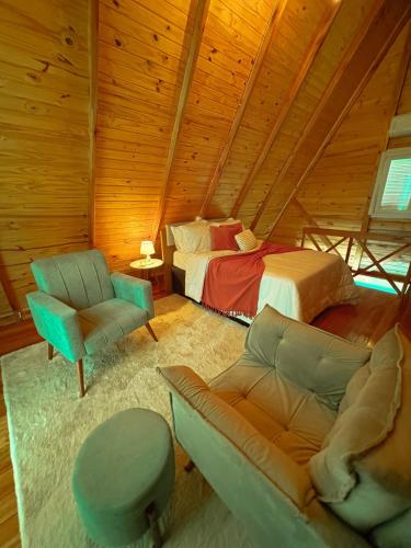 Un dormitorio con una cama, un sofá y una silla. en Cabana dos Coqueiros Para-tí, en Taquara