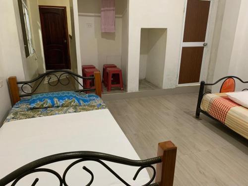 FELIZ ESTADIA Via PRINCIPAL PUERTO LOPEZ في بويرتو لوبيز: غرفة نوم بها سريرين في الغرفة