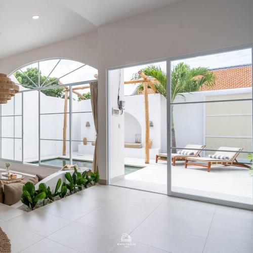 una sala de estar abierta con una gran puerta corredera de cristal en EnyaVillas 1, Brand New Boutique Mediterranean, en Uluwatu