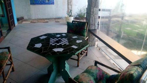 a table and chairs in a room with a chess board on it at Pousada Preziosa Beach Itanhaém in Itanhaém