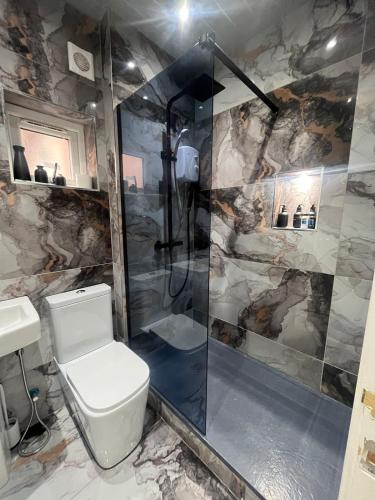 a bathroom with a toilet and a shower at The Central Haven in Manchester