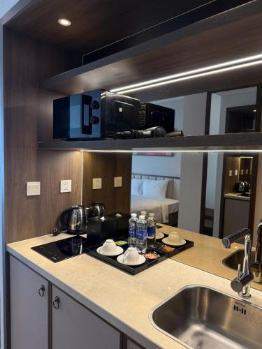 a kitchen counter with a sink and a microwave at Mandala Mui Ne - Beach & Pool Suites in Mui Ne