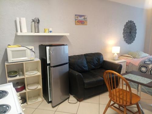 a living room with a couch and a refrigerator at Pinellas Park Oasis in St Petersburg