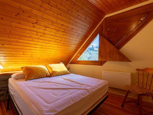 a bed in a wooden room with a window at Maison pour 5 à Génos proche lac et station avec WiFi - FR-1-695-94 in Génos