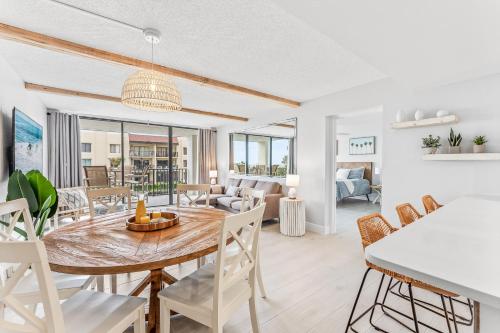 a dining room and living room with a table and chairs at Cape Winds 204 in Cape Canaveral