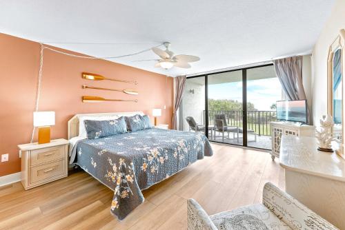 Cape Winds 204 في كيب كانافيرال: غرفة نوم مع سرير وشرفة