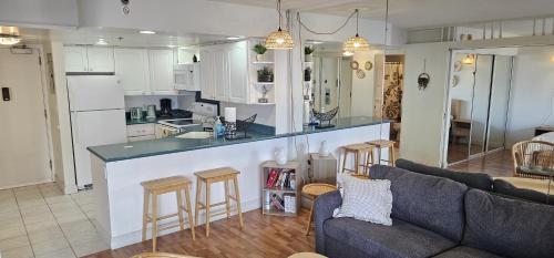 a kitchen and living room with a couch and a counter at Ilikai luxury suites with free parking - unit#1123 in Honolulu